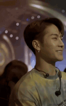 a close up of a person wearing a tie dye shirt and a microphone