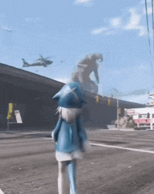 a girl in a blue cat costume is walking down a street with a helicopter flying in the background .
