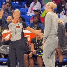 a female basketball referee wearing a shirt that says ' supreme ' on it