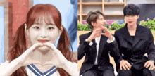 a girl is making a heart shape with her hands and two men are sitting next to each other .
