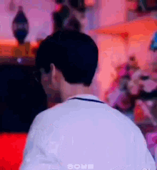 the back of a man 's head is shown in a blurry photo with a purple background .