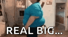 a woman in a blue shirt is dancing in a kitchen with the words `` real big ... '' written on the screen .