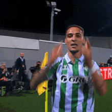 a man wearing a green and white striped shirt that says ggrv