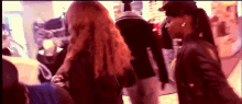 a woman in a black jacket is standing in a crowd