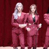 two women in red suits stand next to each other