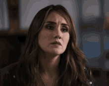 a woman with long brown hair is wearing a necklace