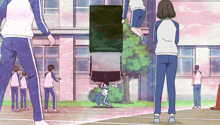 a group of people are standing in front of a building with a car hanging off the side of it