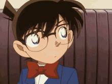 a boy with glasses and a bow tie looks at the camera