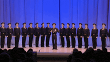 a man stands on a stage with a group of men in uniforms