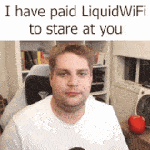 a man sitting in a chair with the words i have paid liquid wifi to stare at you above him