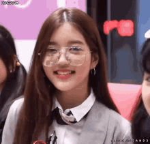 a girl wearing glasses and a white shirt is smiling