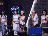 a group of women singing into microphones in front of a cool music sign