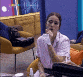 a woman sitting in a chair with a sirius network logo on the wall