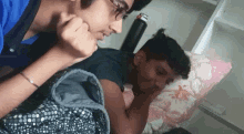 a man and a woman are laying on a bed with a polka dot blanket