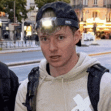 a man wearing a petzl hat and a backpack looks at the camera