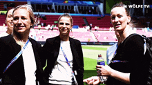 a group of women are standing on a soccer field with a wolfe tv logo in the background