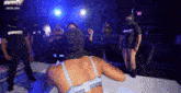 a woman in a bra is dancing in front of a sign that says ' nowthistv ' on it