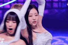 a woman wearing white gloves is dancing on a stage