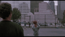 a man is holding a basketball while another man looks on