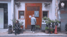 a man stands in front of a building with a sign on the door that says ' chinese restaurant ' on it
