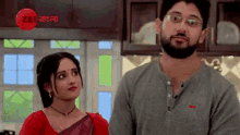 a man and a woman are standing in a kitchen .