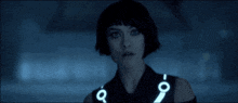 a woman is wearing a black vest with the letter c on the front