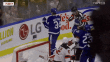 a hockey game is being played in front of an lg advertisement