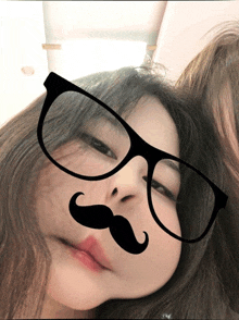 a girl wearing glasses and a fake mustache