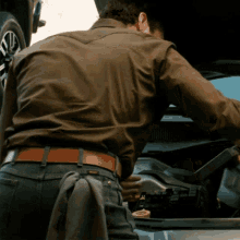 a man looking under the hood of a car