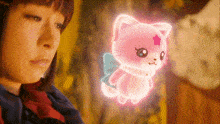 a girl is looking at a pink cat with wings and a star on its head