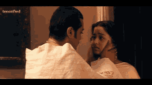 a man is touching a woman 's face with the word tenerified visible in the corner