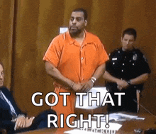 a man in an orange jumpsuit is standing in front of a table with a sign that says got that right .