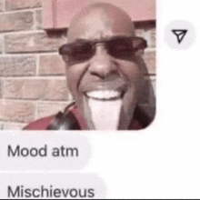 a man wearing sunglasses is smiling in front of a brick wall and talking on a cell phone .