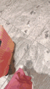 a pink suitcase is sitting on a tile floor