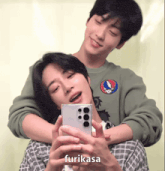 two young men are taking a picture of themselves with a cell phone and the word furikasa is on the bottom