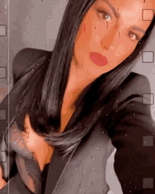 a woman taking a selfie with a black jacket and red lips