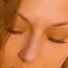 a close up of a woman 's face with her eyes closed