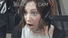 a woman wearing headphones has a surprised look on her face and the words reaction cam above her