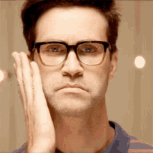 a man wearing glasses is making a funny face