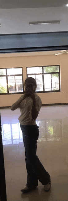 a woman is taking a picture of herself in a mirror