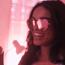 a woman wearing heart shaped sunglasses is smiling and looking at the camera