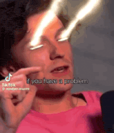 a man in a pink shirt is pointing at his eyes and saying `` if you have a problem ''