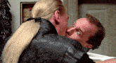 a man and a woman are kissing in a room