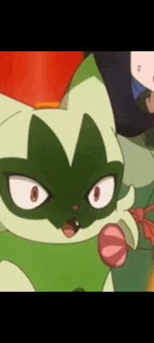 a close up of a green and white cartoon cat with a pink tongue sticking out .