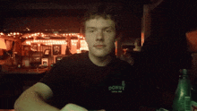 a man wearing a black shirt that says donut looks at the camera