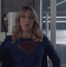a woman in a superman costume is making a face