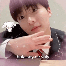 a boy in a suit and tie with the words hola soy de valy below him