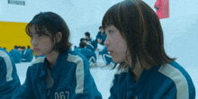 two girls wearing blue jackets with the number 067 on them