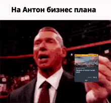a man in a suit and tie is holding a phone in front of a sign that says missions of victory