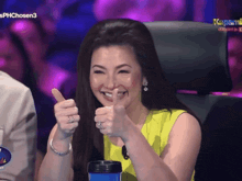 a woman giving a thumbs up in front of a sign that says kapamilya